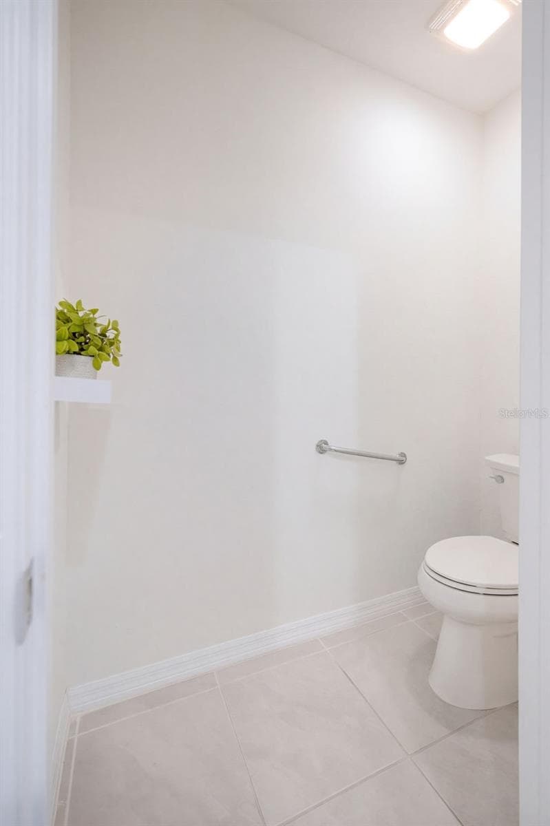 A private water closet includes a comfort-height toilet with a safety grab bar - 2415 BRASSIE CT, WINTER HAVEN