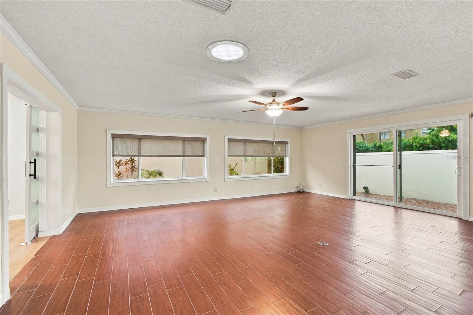 Let's enter the living/family room. It has plenty of space, with dimensions of 18 x 22. Wow, the windows and sliding door have a tint, and there are roll-down hurricane shutters. The room also features a Solar Tube for natural light. - 2254 HERON CIR, CLEARWATER