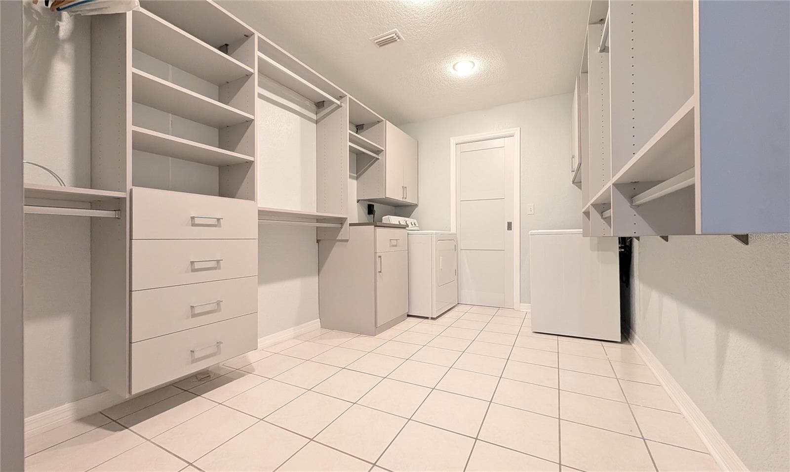 This is a spacious 8 x 13, walk-in closet. Yes, there is the washer and dryer at the end. Wash, fold, and hang all in one spot. You can relocate them to the garage, but why? - 2254 HERON CIR, CLEARWATER