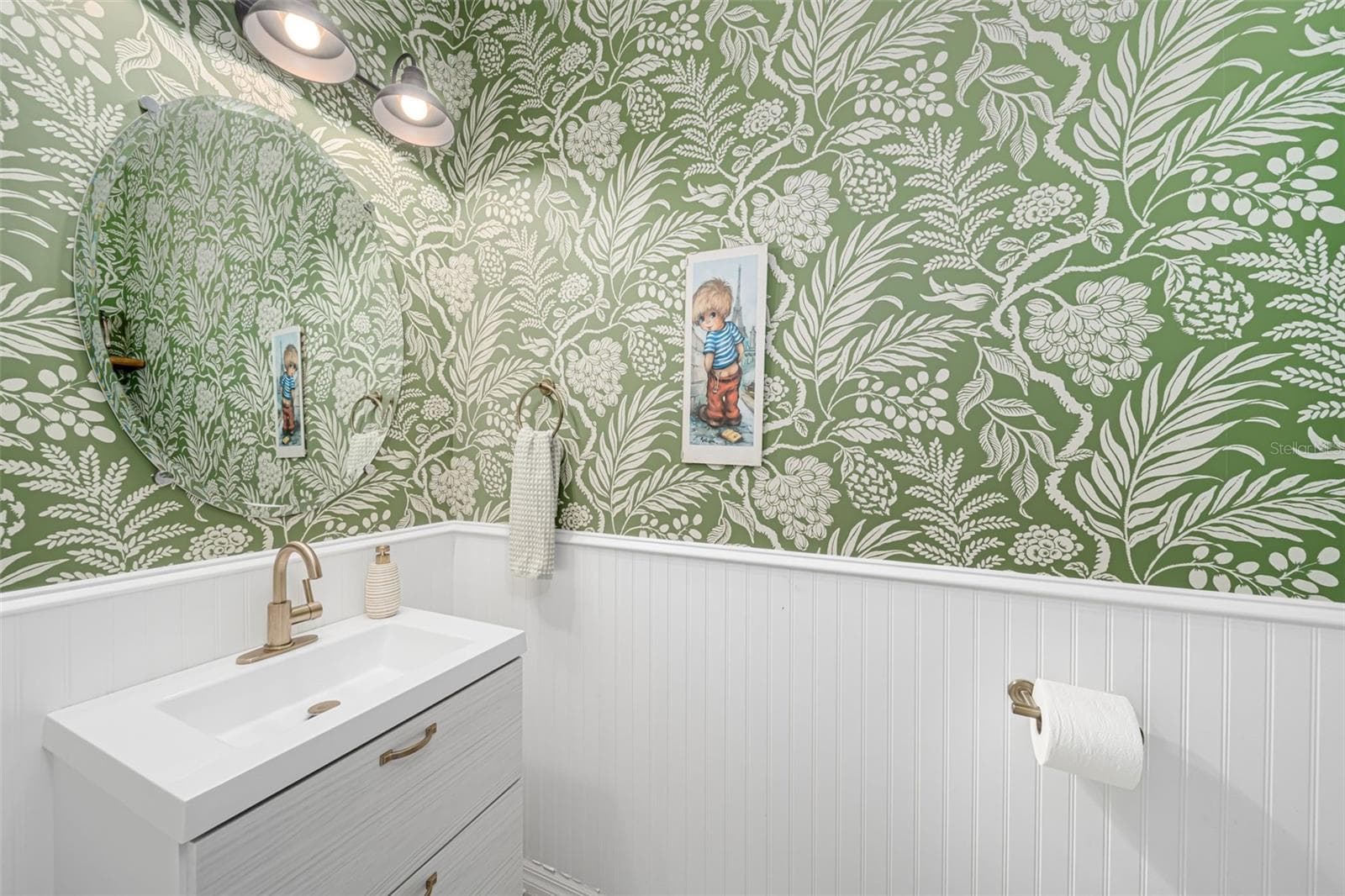 Guest bathroom enhanced by stylish wallpaper and a touch of personality. - 6195 ANISE DR, SARASOTA