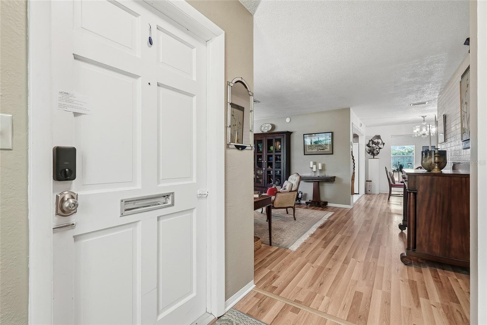 An inviting entry opens to comfortable living spaces, with warm wood flooring connecting the living and dining areas. - 1890 62ND AVE S, ST PETERSBURG