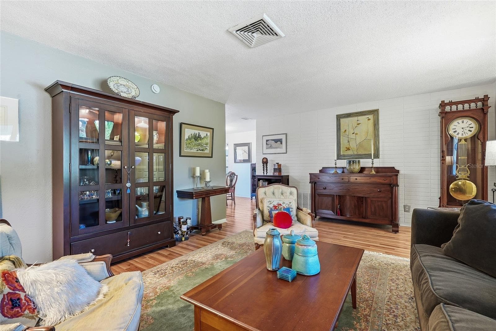 A painted brick accent wall adds texture and character, while the nearby dining area keeps entertaining comfortably connected. - 1890 62ND AVE S, ST PETERSBURG