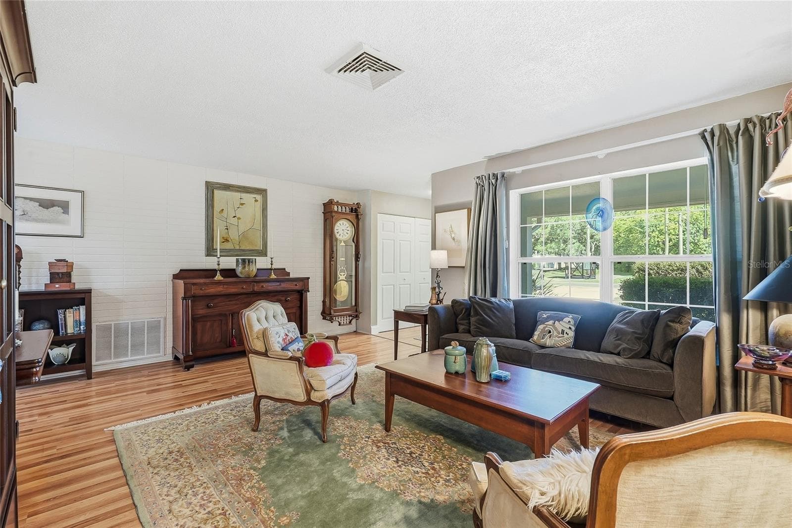 A generous front window frames leafy views and fills this welcoming gathering space with natural light. - 1890 62ND AVE S, ST PETERSBURG