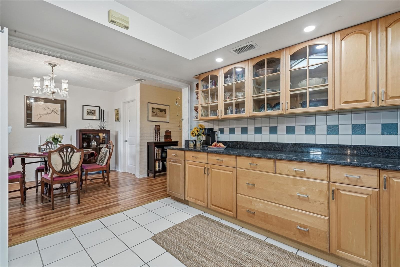 Glass-front cabinetry adds charm above an expansive counter, perfect for meal preparation or serving a spread just steps from the dining table. - 1890 62ND AVE S, ST PETERSBURG