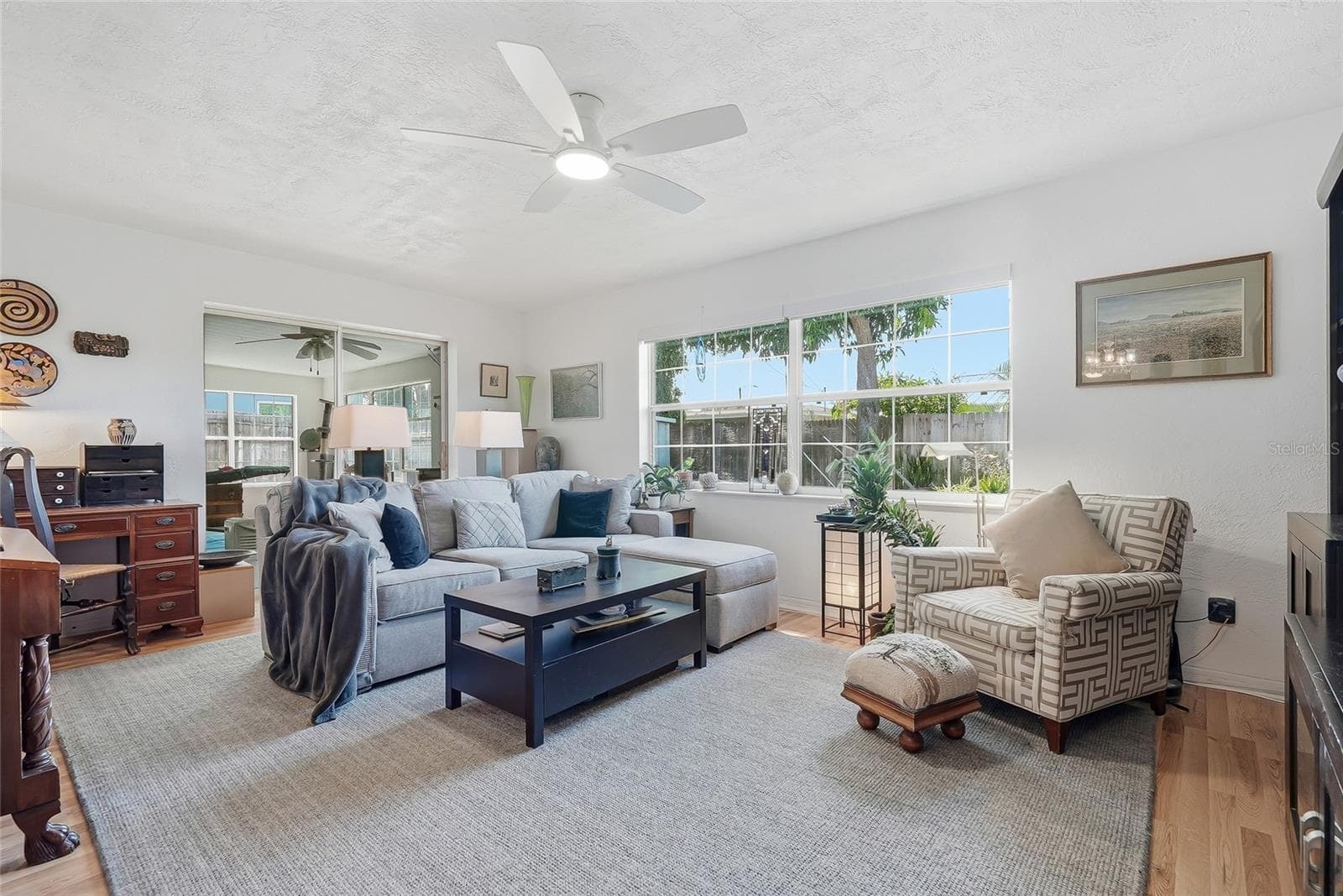 Sunlight pours through a wide window in the family room, while sliding glass doors connect this comfortable gathering space to the enclosed Florida room. - 1890 62ND AVE S, ST PETERSBURG
