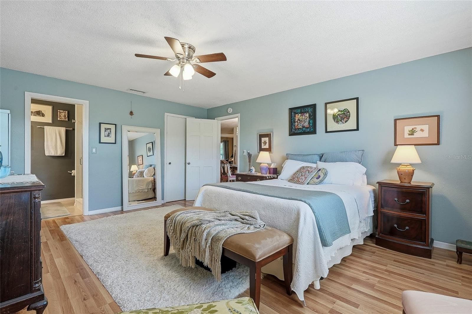 Unwind in a generously sized primary suite with warm wood flooring and the everyday convenience of a private ensuite bath. - 1890 62ND AVE S, ST PETERSBURG