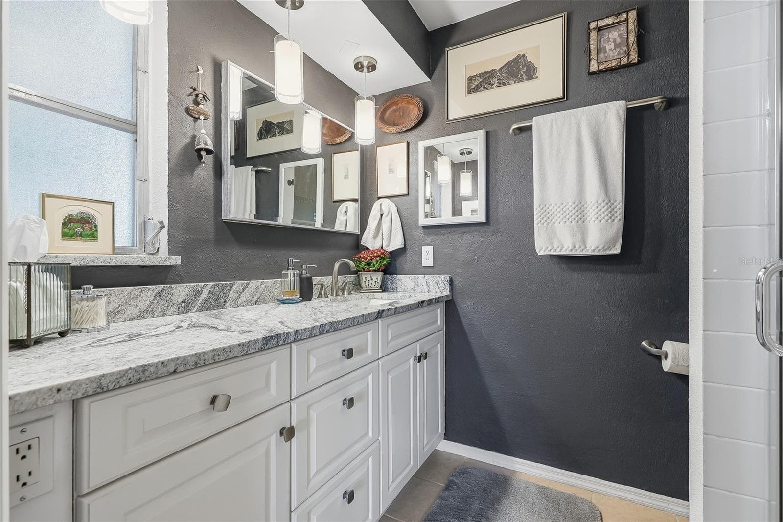 Start your day with generous vanity space, plentiful drawer storage, and pendant lighting that adds a stylish touch to the primary bath. - 1890 62ND AVE S, ST PETERSBURG