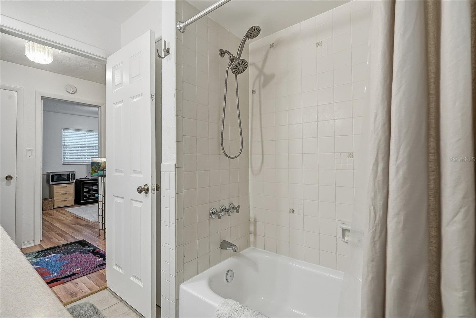 Enjoy the flexibility of a full tub and shower combination, finished with classic white tile and a handheld showerhead. - 1890 62ND AVE S, ST PETERSBURG