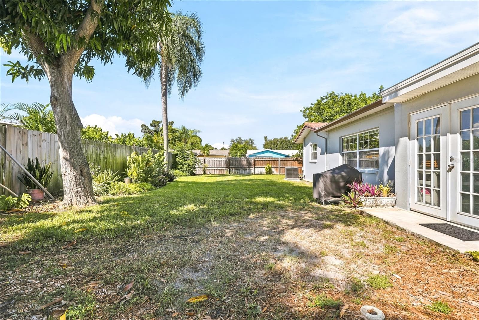 Step through the Florida room’s French doors into a spacious backyard ready for afternoon barbecues and relaxed outdoor entertaining. - 1890 62ND AVE S, ST PETERSBURG