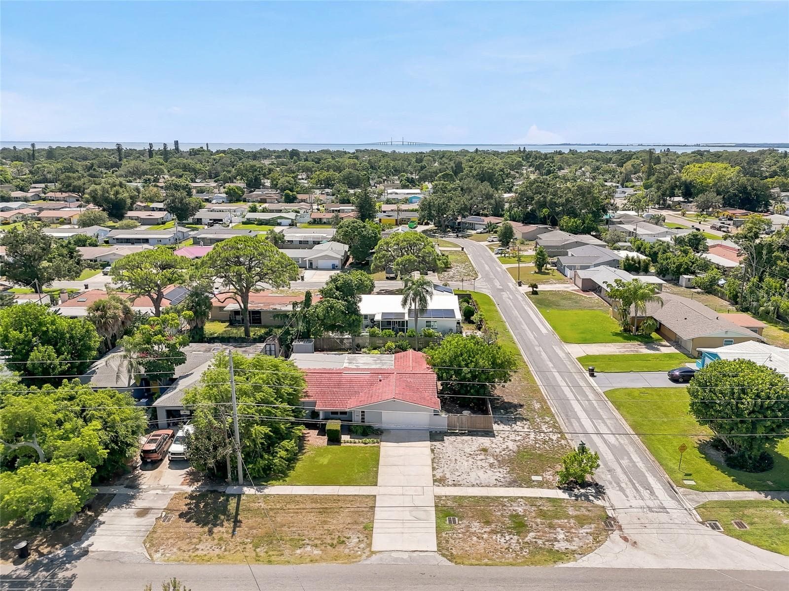See the corner setting from above, with a broad driveway, mature trees, and generous outdoor space surrounding the home. - 1890 62ND AVE S, ST PETERSBURG
