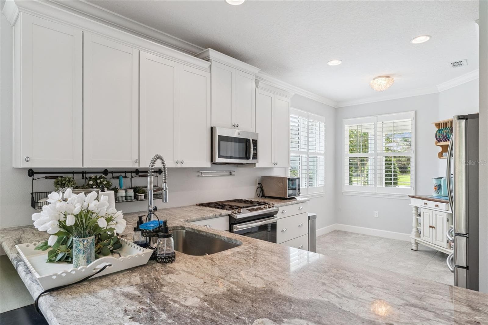 Kitchen w/ a single basin undermount stainless steel sink, 5-burner natural gas range & Plantation style shutters - 1305 HAYTON AVE., DELAND