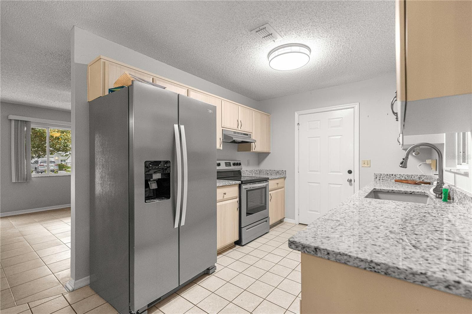 KITCHEN STAINLESS STEEL APPLIANCES TO FRONT LIVING ROOM WINDOW VIEW - 10434 SE 178TH PL, SUMMERFIELD