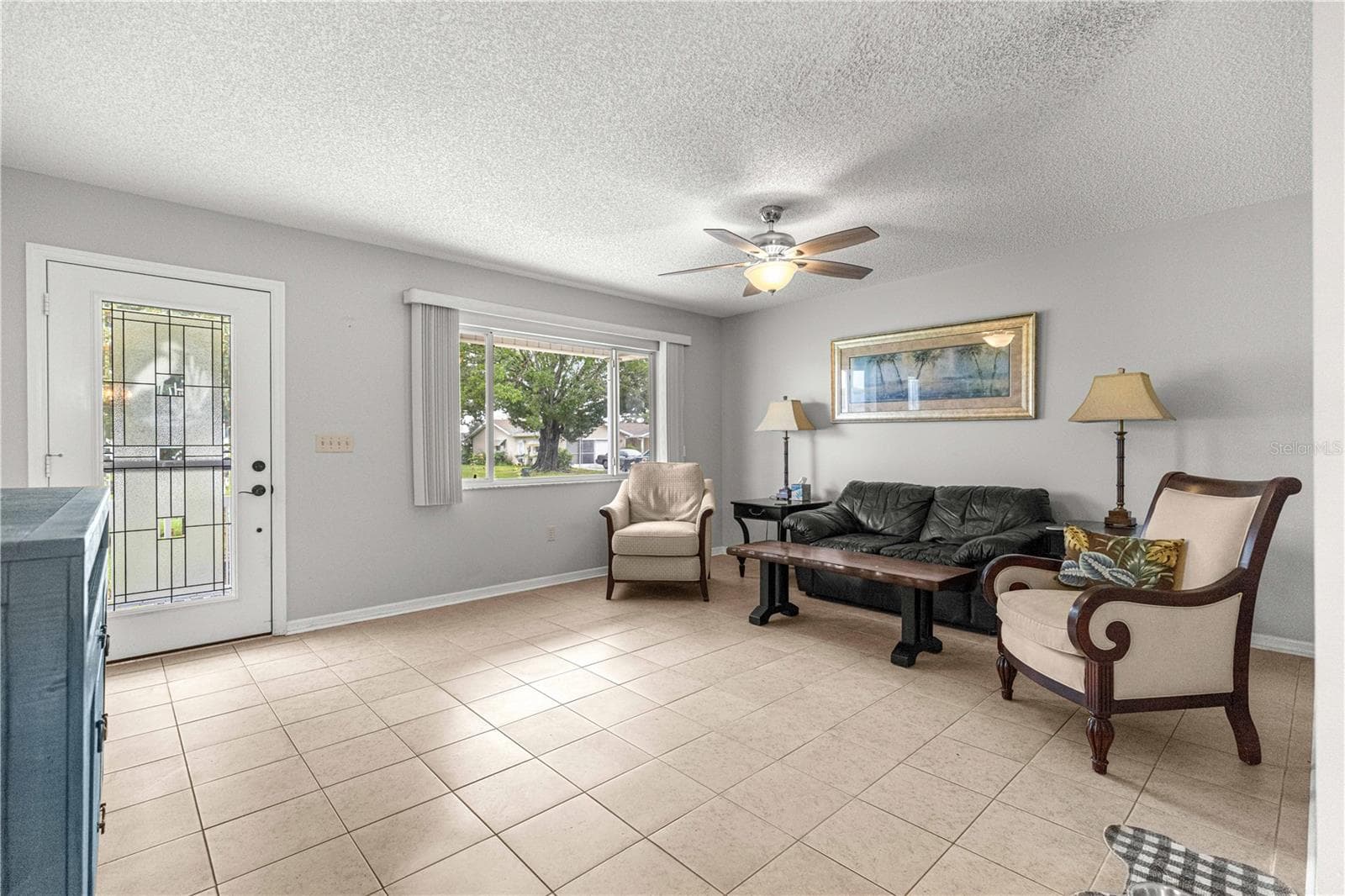 LIVING ROOM TO FRONT DOOR AND WINDOW DISPLAYING TILED FLOOR AND NEWER FAN - 10434 SE 178TH PL, SUMMERFIELD