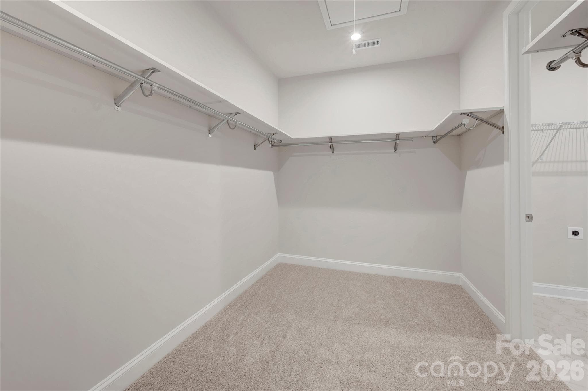 Primary walk-in closet with door connection to the laundry room - Fort Mill