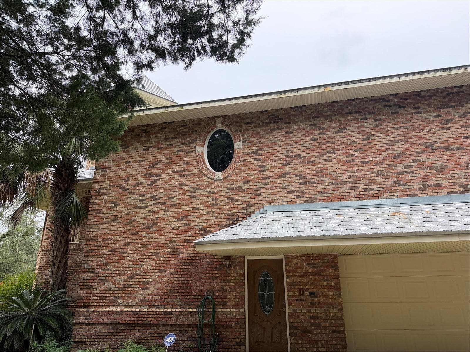 Garage, front entry door,oval window is in primary bathroom - 5422 CYRIL DR, DADE CITY