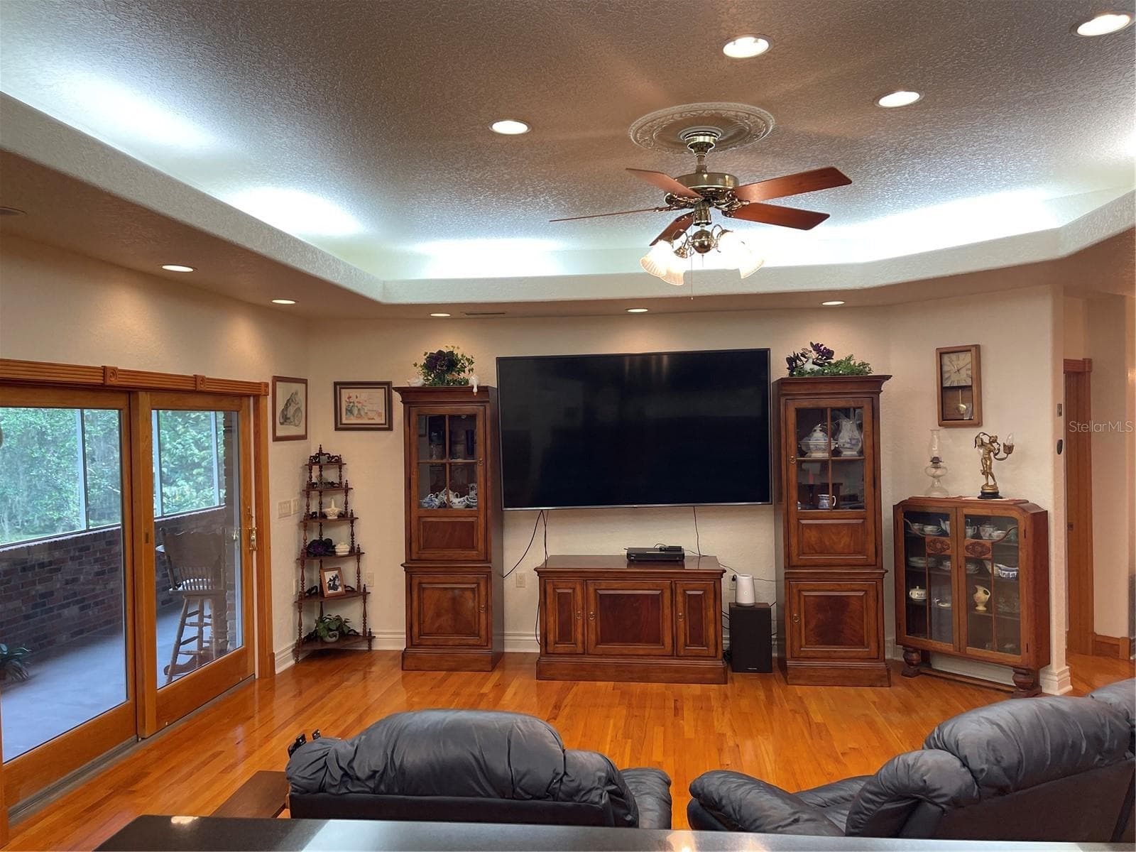 Living room exits through Anderson sliding glass doors to the screened balcony - 5422 CYRIL DR, DADE CITY