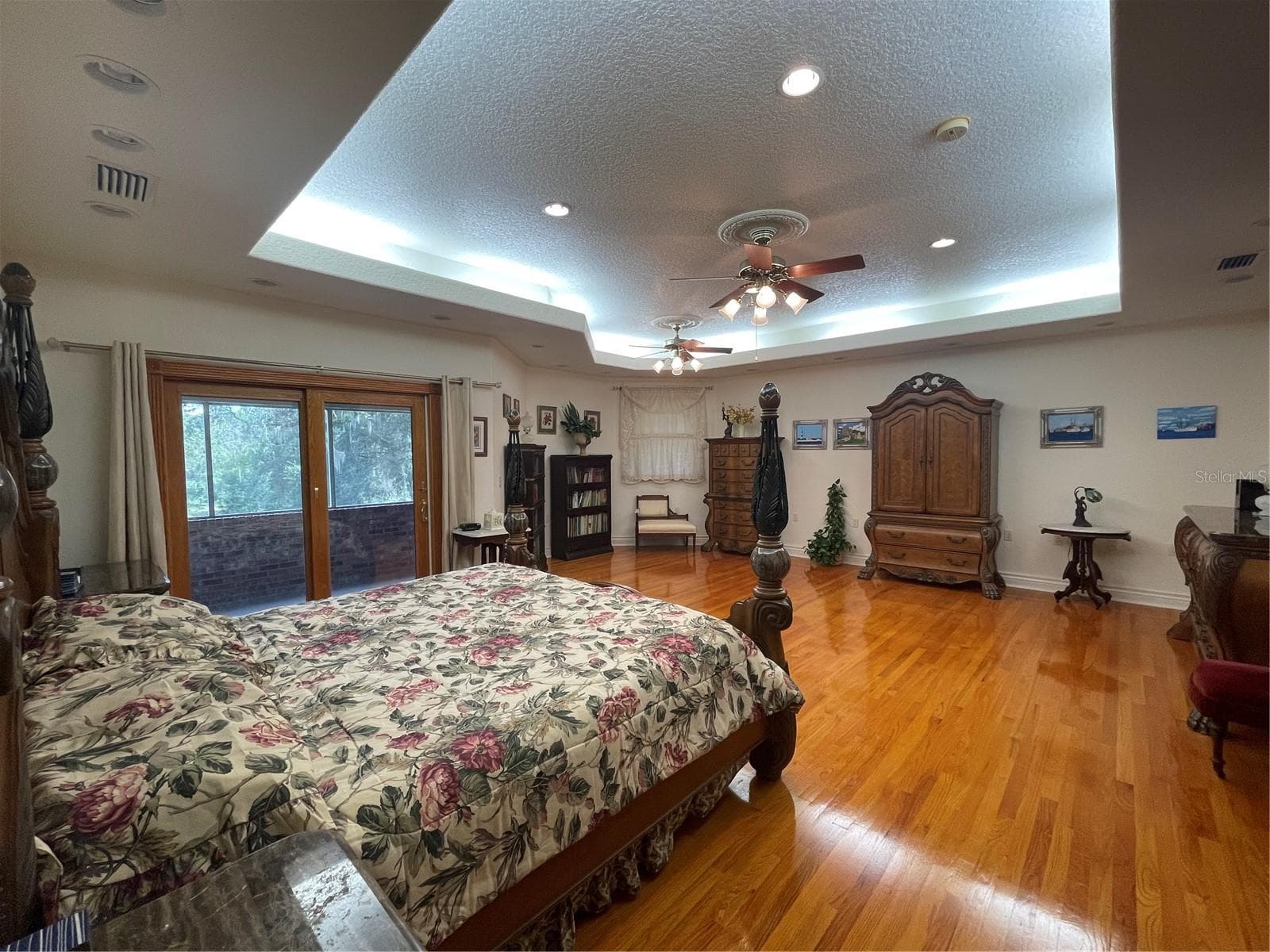 The Anderson sliding glass doors in primary bedroom lead out to screened balcony that faces the river. - 5422 CYRIL DR, DADE CITY