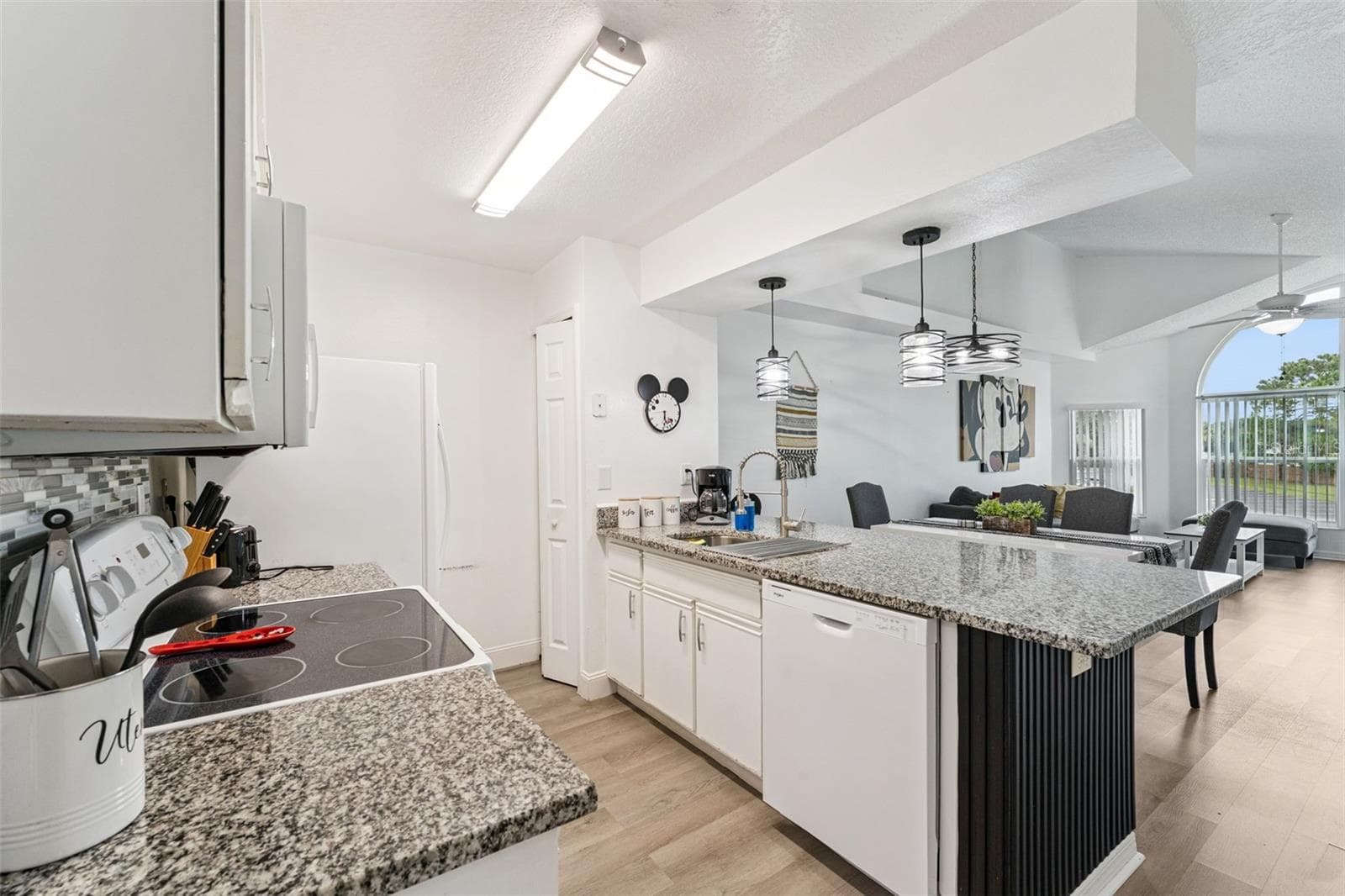 Open Kitchen Perspective: Open-concept kitchen layout showing the smooth transition into the main living and dining spaces, ideal for hosting and daily living. - 5017 LAGUNA BAY CIR #100, KISSIMMEE