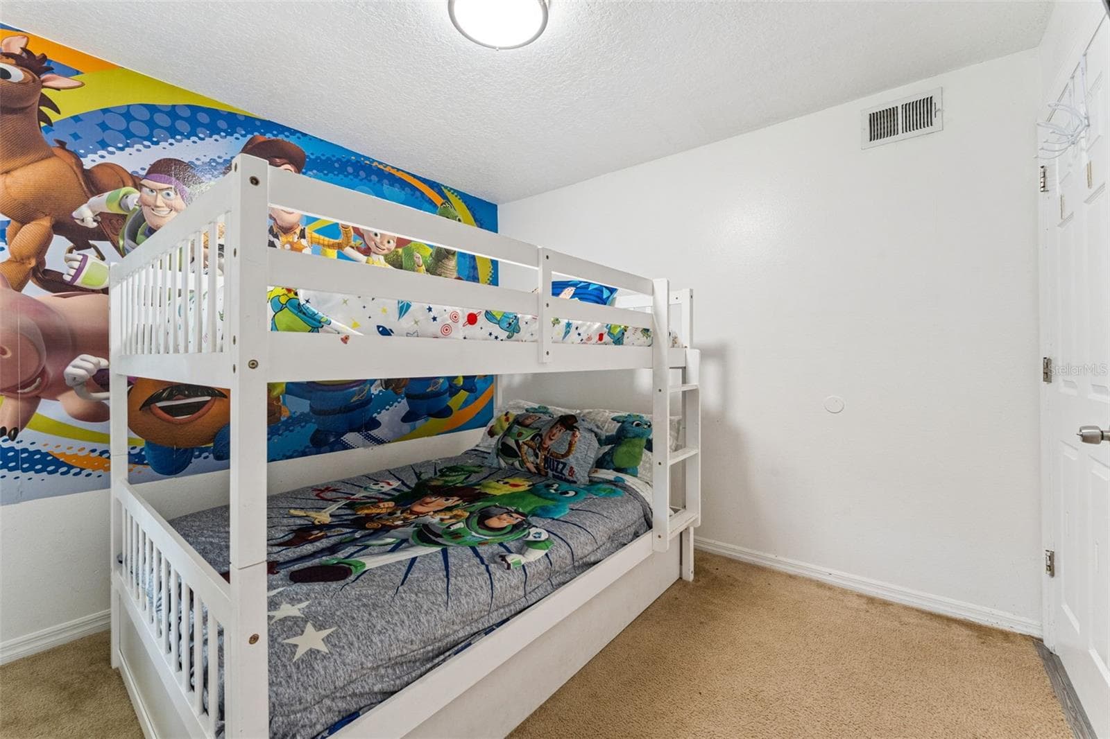 Bunk Bed Room: Fun character-themed guest room equipped with sturdy white wooden bunk beds and plush carpeting. - 5017 LAGUNA BAY CIR #100, KISSIMMEE
