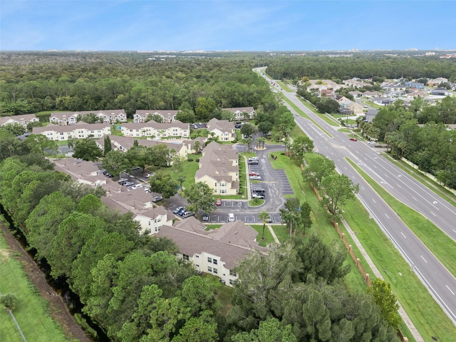 Panoramic Community View: Panoramic drone view capturing the expansive residential complex layout, mature tree canopy, water features, and regional connectivity. - 5017 LAGUNA BAY CIR #100, KISSIMMEE