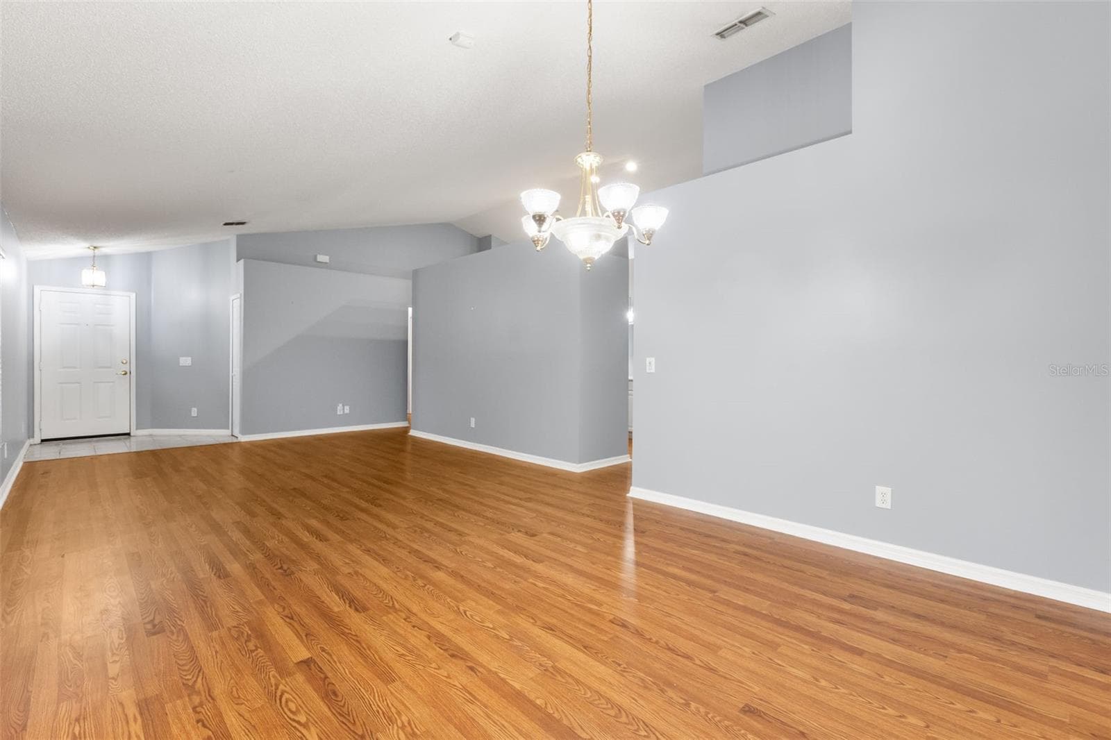 View of living room and front entry door rom dining room - 755 VIA MILANO, APOPKA