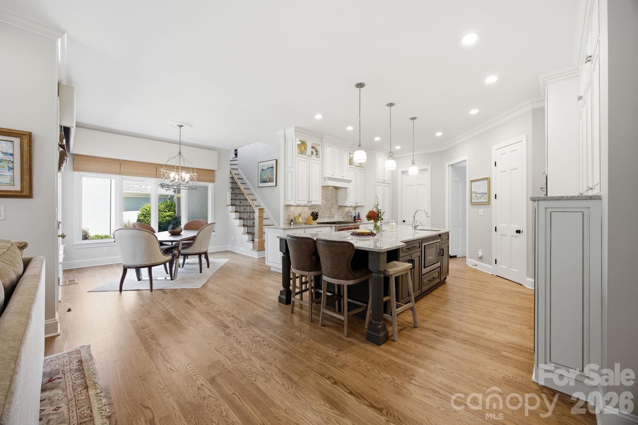 Gather and celebrate in this warm, open-concept living and dining space flooded with natural light. - 18416 Peninsula Club Drive, Cornelius