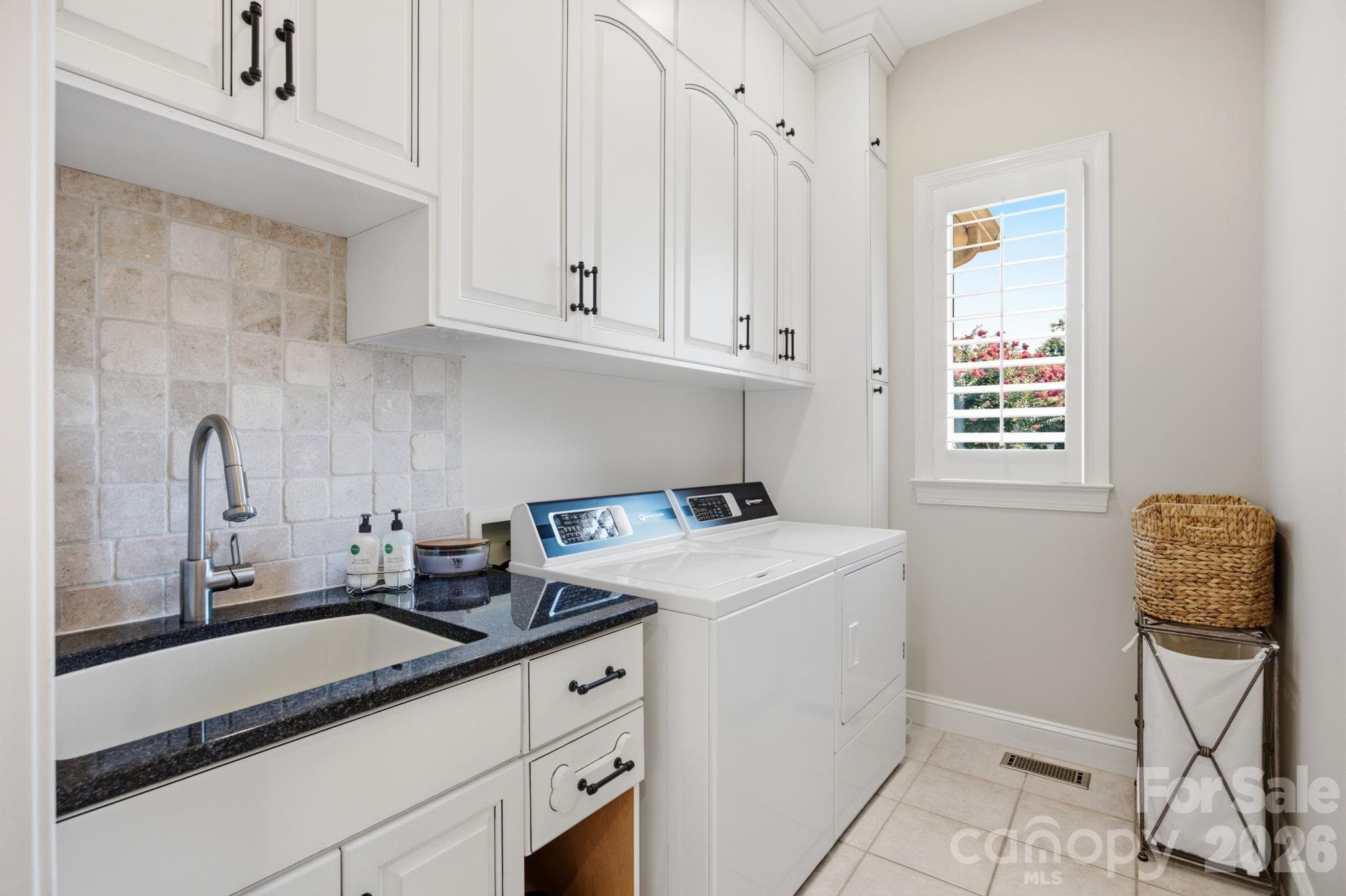 A clean, functional laundry room equipped with upper storage cabinets. - 18416 Peninsula Club Drive, Cornelius