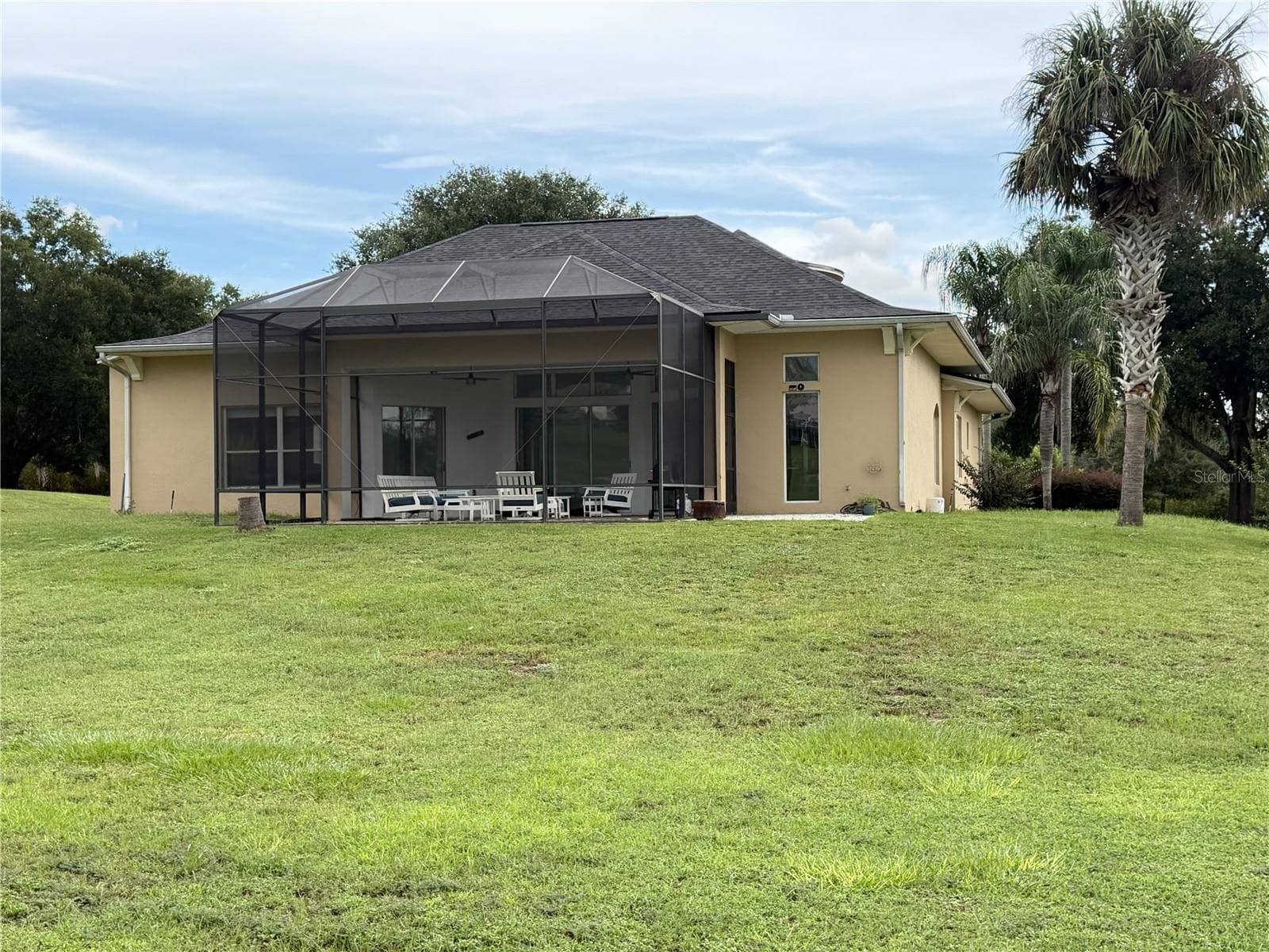 Rear elevation with screened lanai and expansive lawn. - 39539 HARBOR HILLS BLVD, LADY LAKE