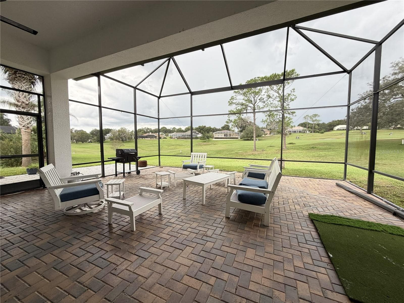 Large screened lanai with brick pavers and golf-course views. - 39539 HARBOR HILLS BLVD, LADY LAKE