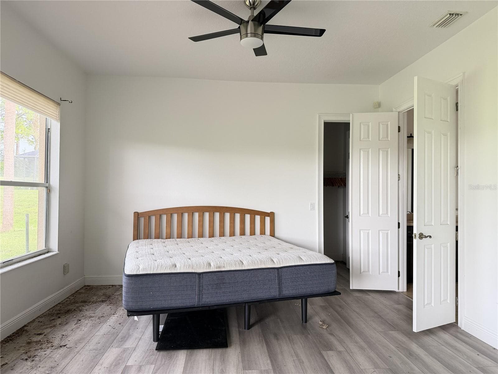 Main-floor primary bedroom with luxury vinyl flooring and ceiling fan. - 39539 HARBOR HILLS BLVD, LADY LAKE