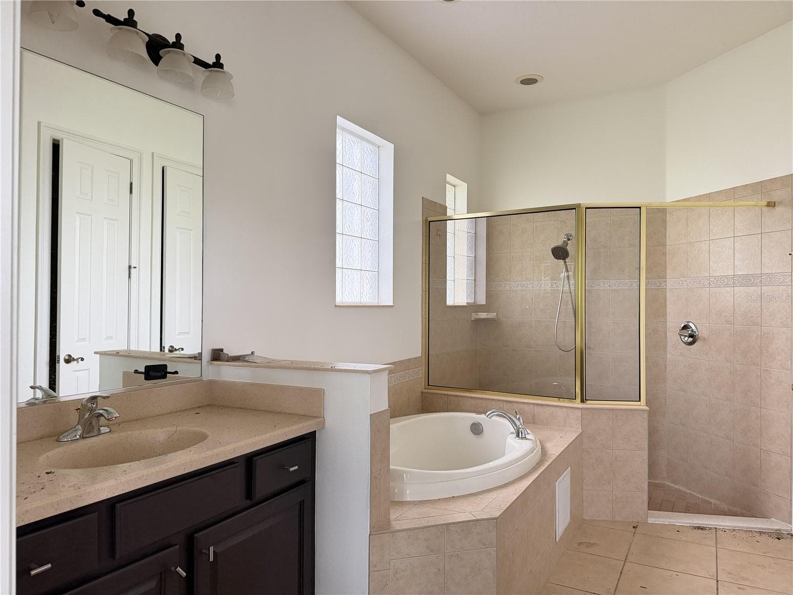 Primary bath with soaking tub, tiled shower, and separate sink vanities. - 39539 HARBOR HILLS BLVD, LADY LAKE