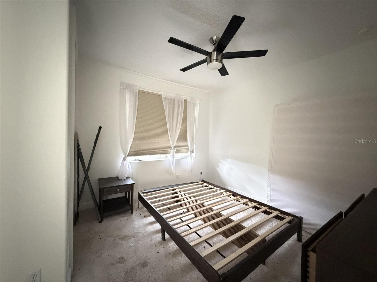 Third bedroom with ceiling fan and exterior window; carpet shows soiling. - 39539 HARBOR HILLS BLVD, LADY LAKE