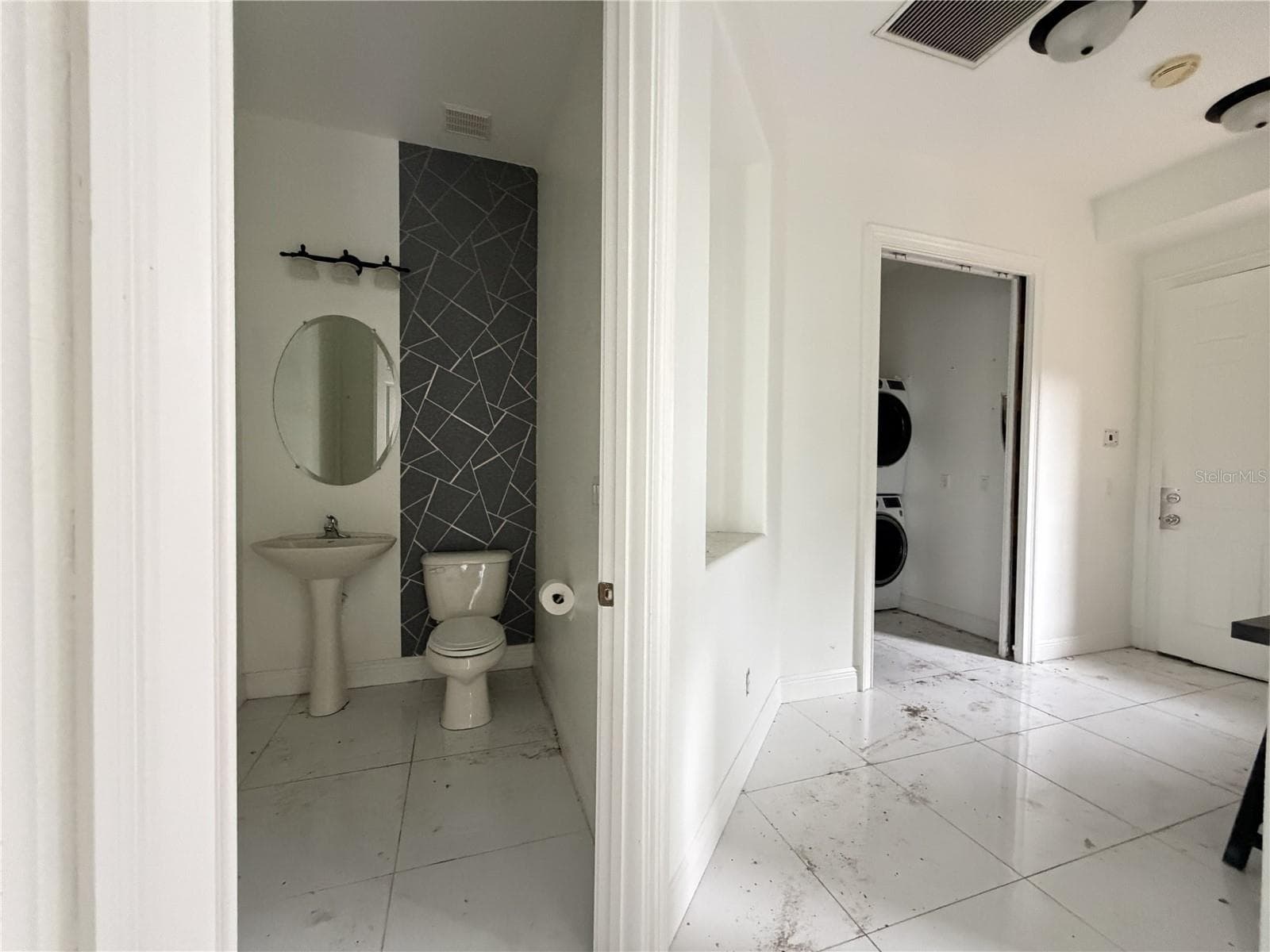 Half bathroom with pedestal sink and decorative accent wall. - 39539 HARBOR HILLS BLVD, LADY LAKE