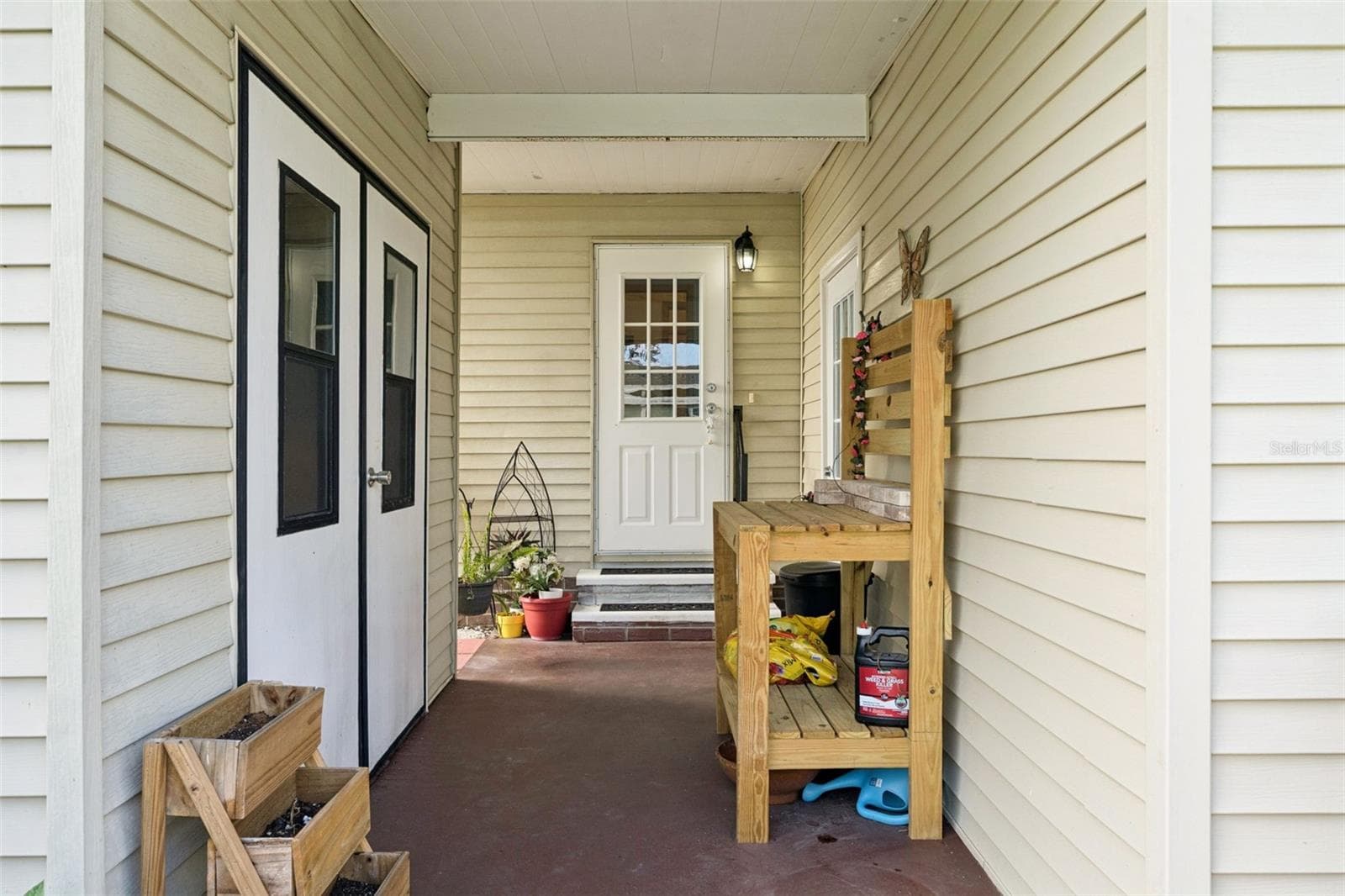 Covered front porch at the main entry, with double doors to the exterior storage room - 25038 CLIFFORD HL, LEESBURG