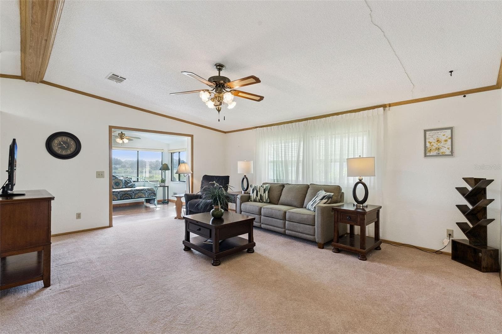 Living room with vaulted ceiling, ceiling fan and an opening into the sunroom - 25038 CLIFFORD HL, LEESBURG