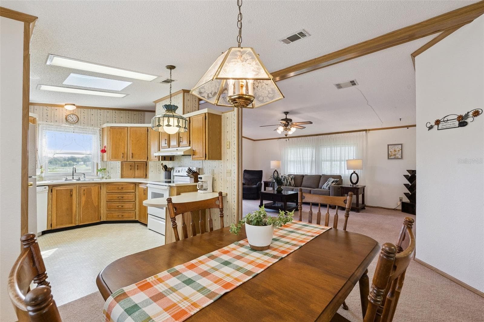 Dining room open to the kitchen with skylights and the living room beyond - 25038 CLIFFORD HL, LEESBURG