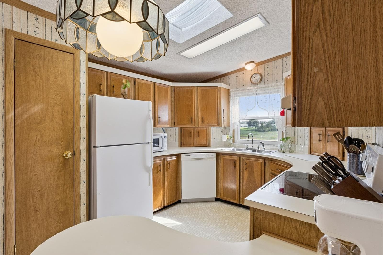 Kitchen with skylight, wood cabinetry, and a window over the sink overlooking the marsh - 25038 CLIFFORD HL, LEESBURG