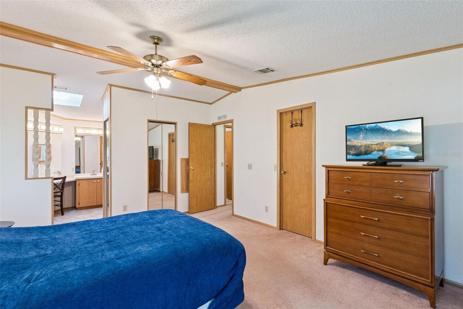 Primary bedroom with ceiling fan and an open view to the en-suite vanity - 25038 CLIFFORD HL, LEESBURG