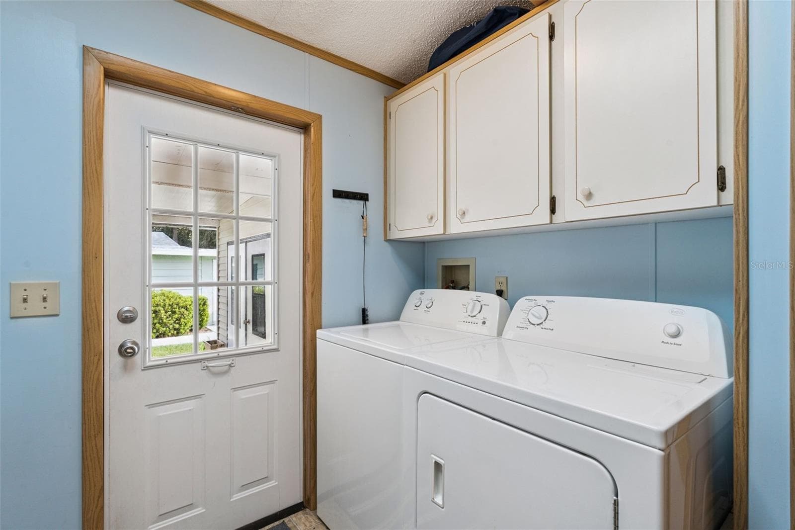 Laundry room with washer, dryer, storage cabinets and door to the front porch - 25038 CLIFFORD HL, LEESBURG