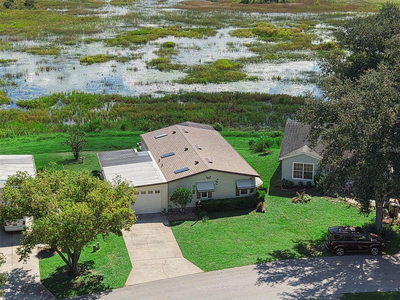 Close aerial view of the home, driveway and the marsh behind - 25038 CLIFFORD HL, LEESBURG