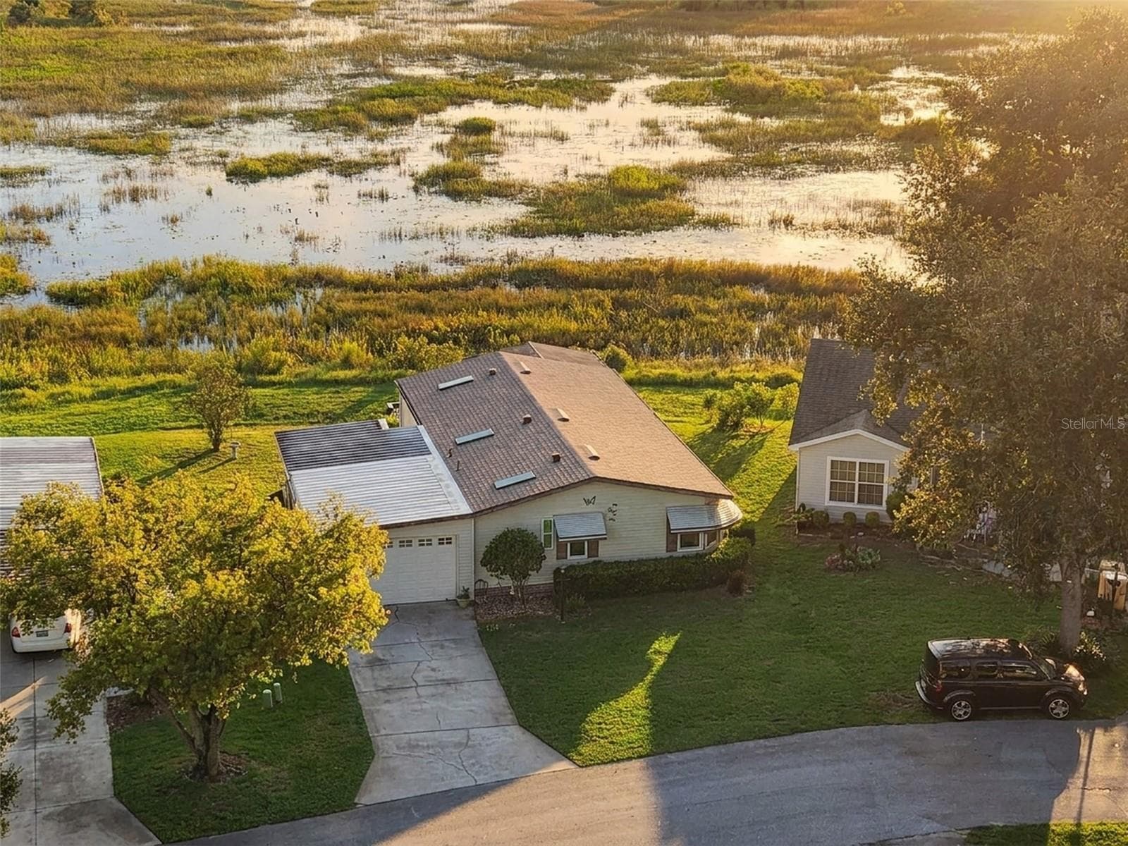 Digitally enhanced golden-hour light: close aerial view of the home with the marsh behind - 25038 CLIFFORD HL, LEESBURG