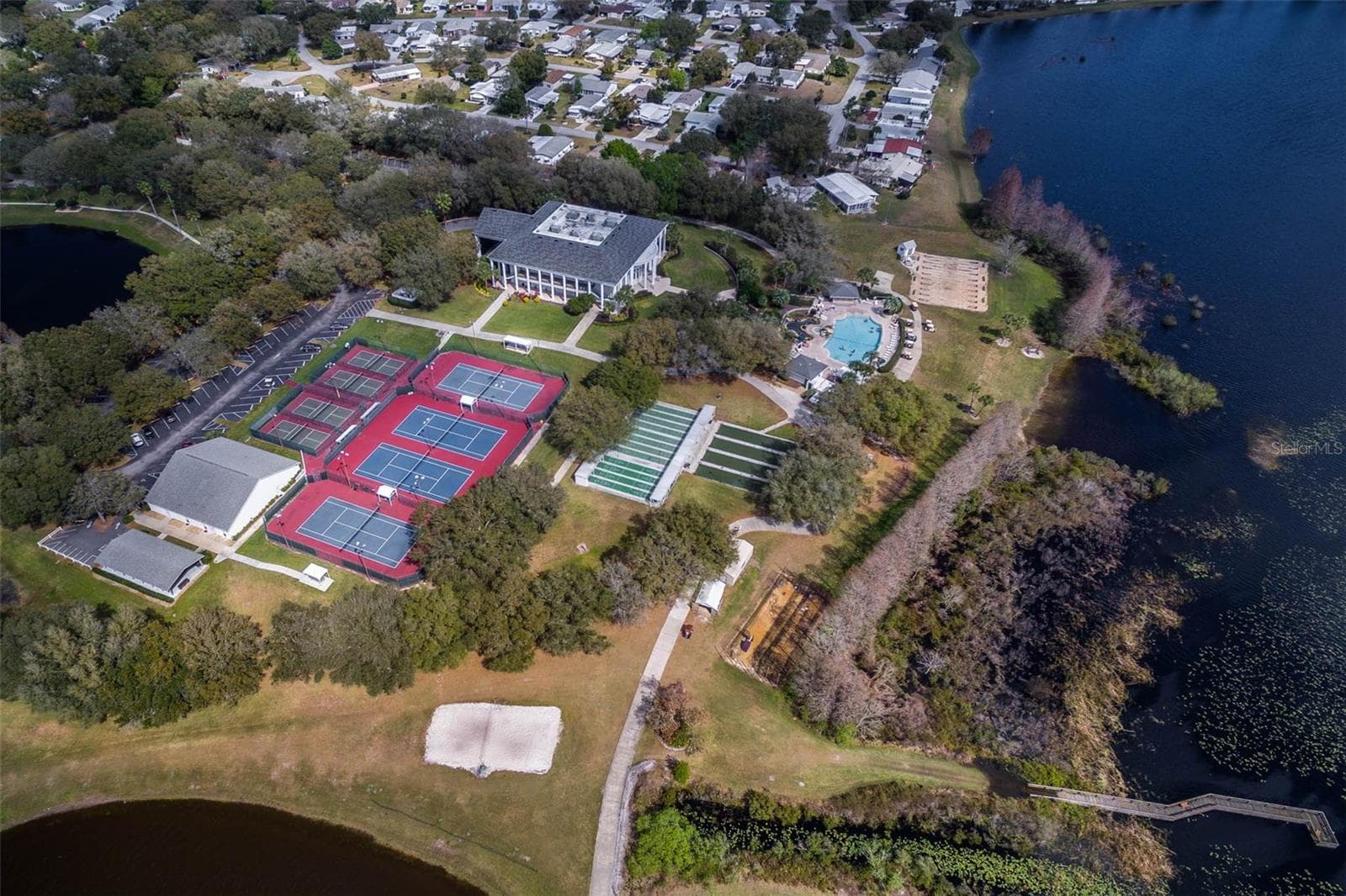 Community amenity: aerial view of the clubhouse, courts and pool along the lake - 25038 CLIFFORD HL, LEESBURG