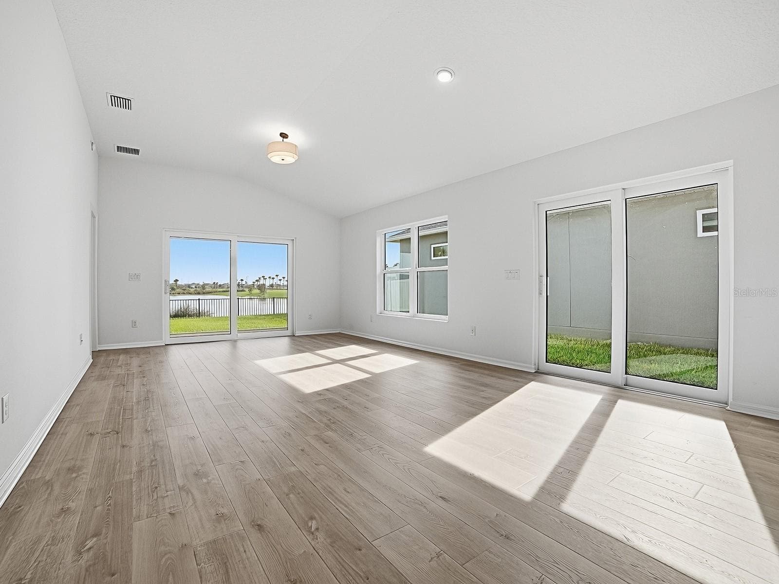 A view of the Dining and living room looking back at the BEAUTIFUL pond view behind your yard that has room for a pool - 1359 DARREN DR, THE VILLAGES
