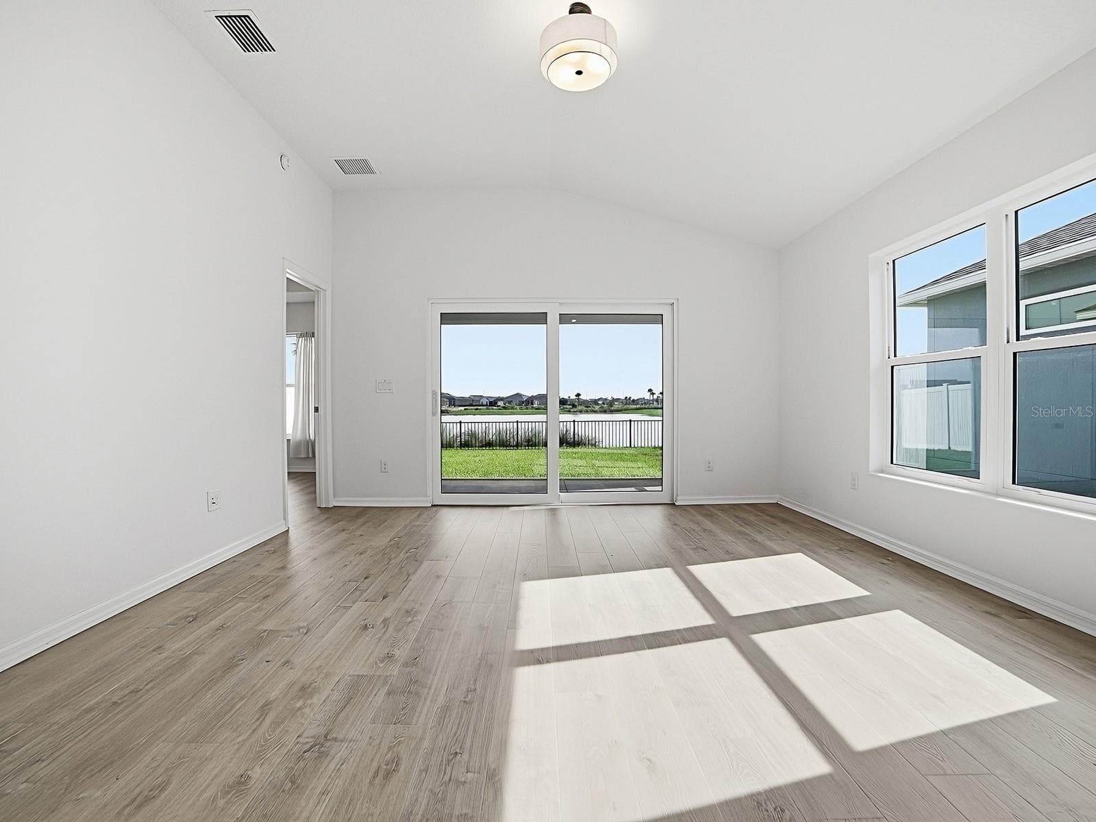 Another view of the living room also looking at the door on the left leading to the primary - 1359 DARREN DR, THE VILLAGES