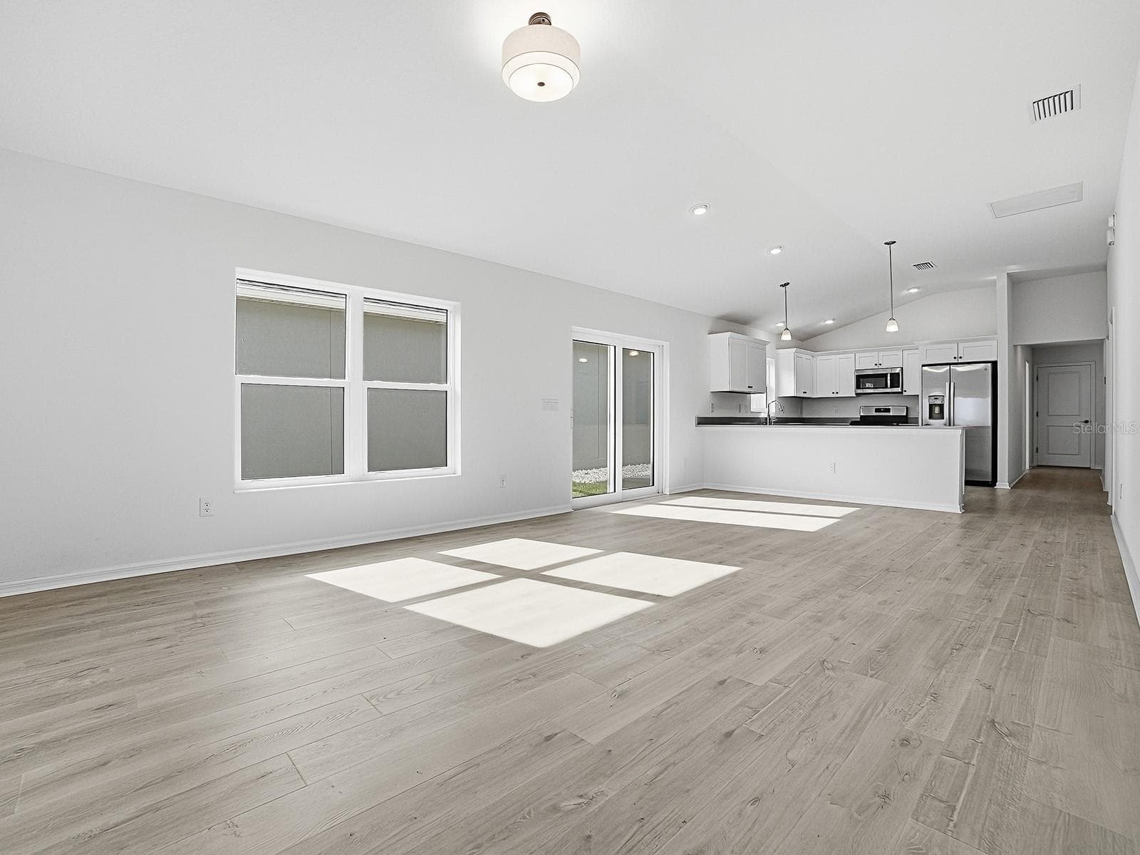 View of living and dining area and kitchen from primary bedroom - 1359 DARREN DR, THE VILLAGES