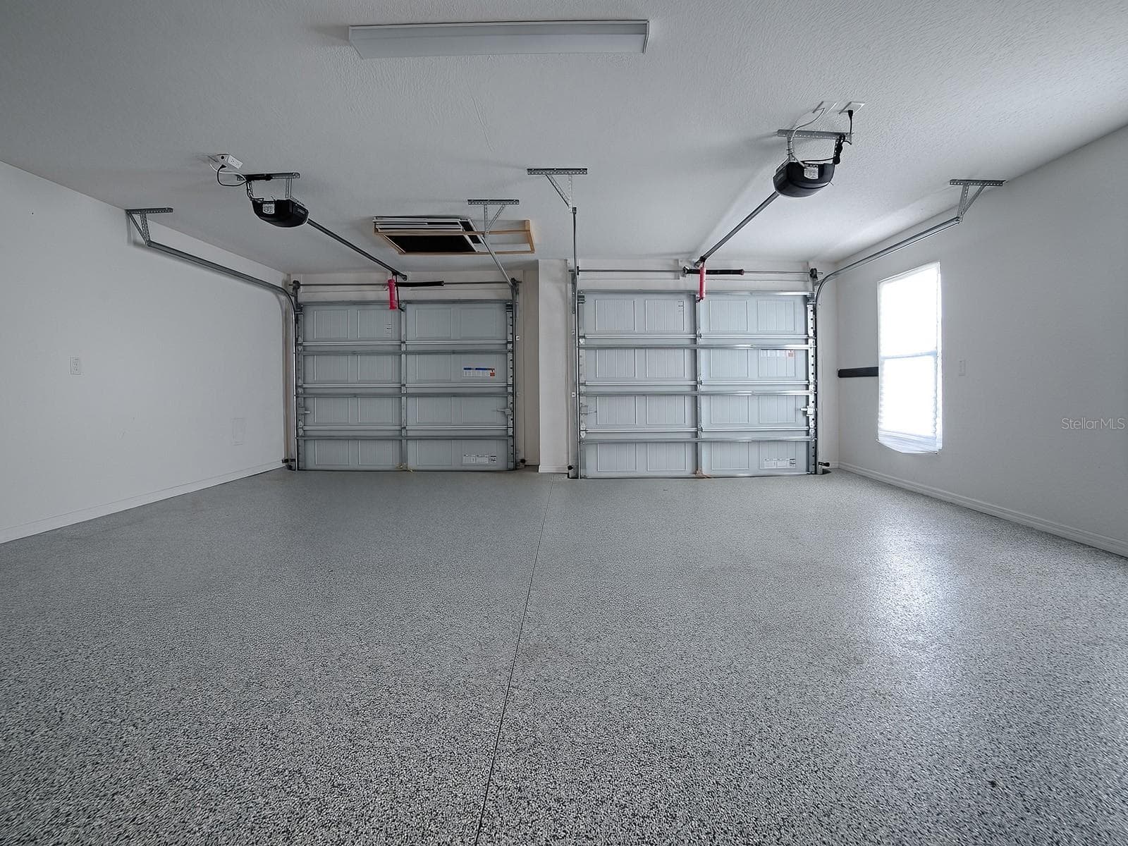 Picture of garage from door to home. 2 large bays for cars, trucks, and or multiple golf carts - 1359 DARREN DR, THE VILLAGES