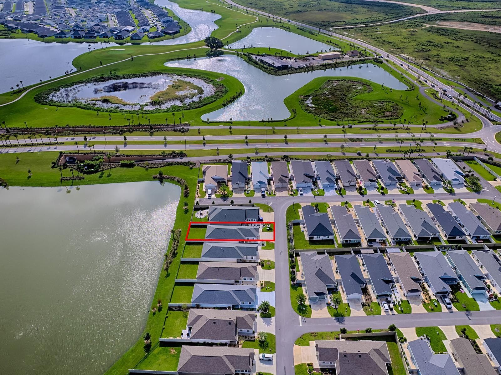 A view from the drone looking at the nearby golf courses and preserve areas. House is marked in red for ease of understanding - 1359 DARREN DR, THE VILLAGES