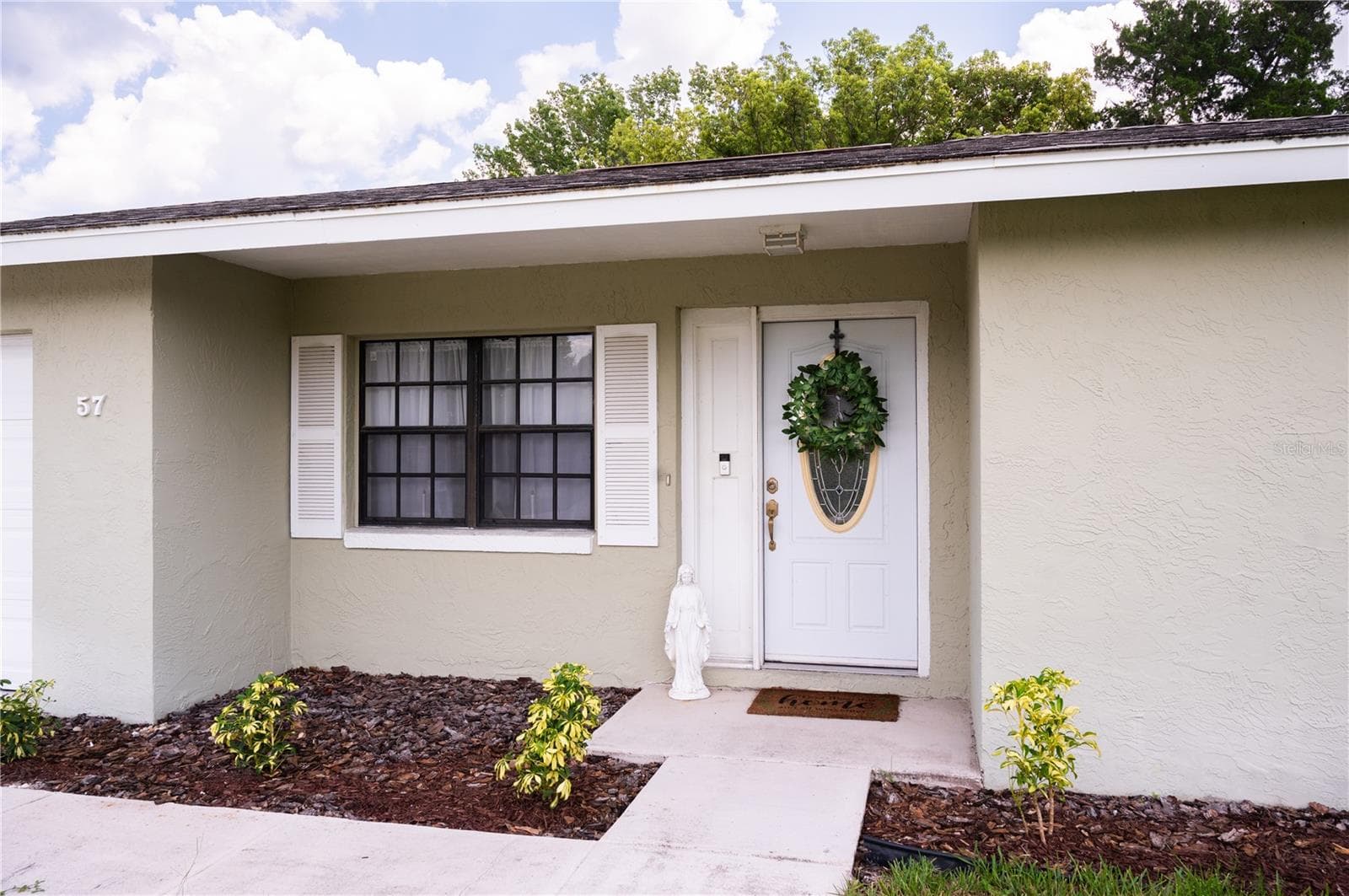 Front entrance featuring a view of the front door and integrated Ring security system. - 57 FORRESTER PL, PALM COAST