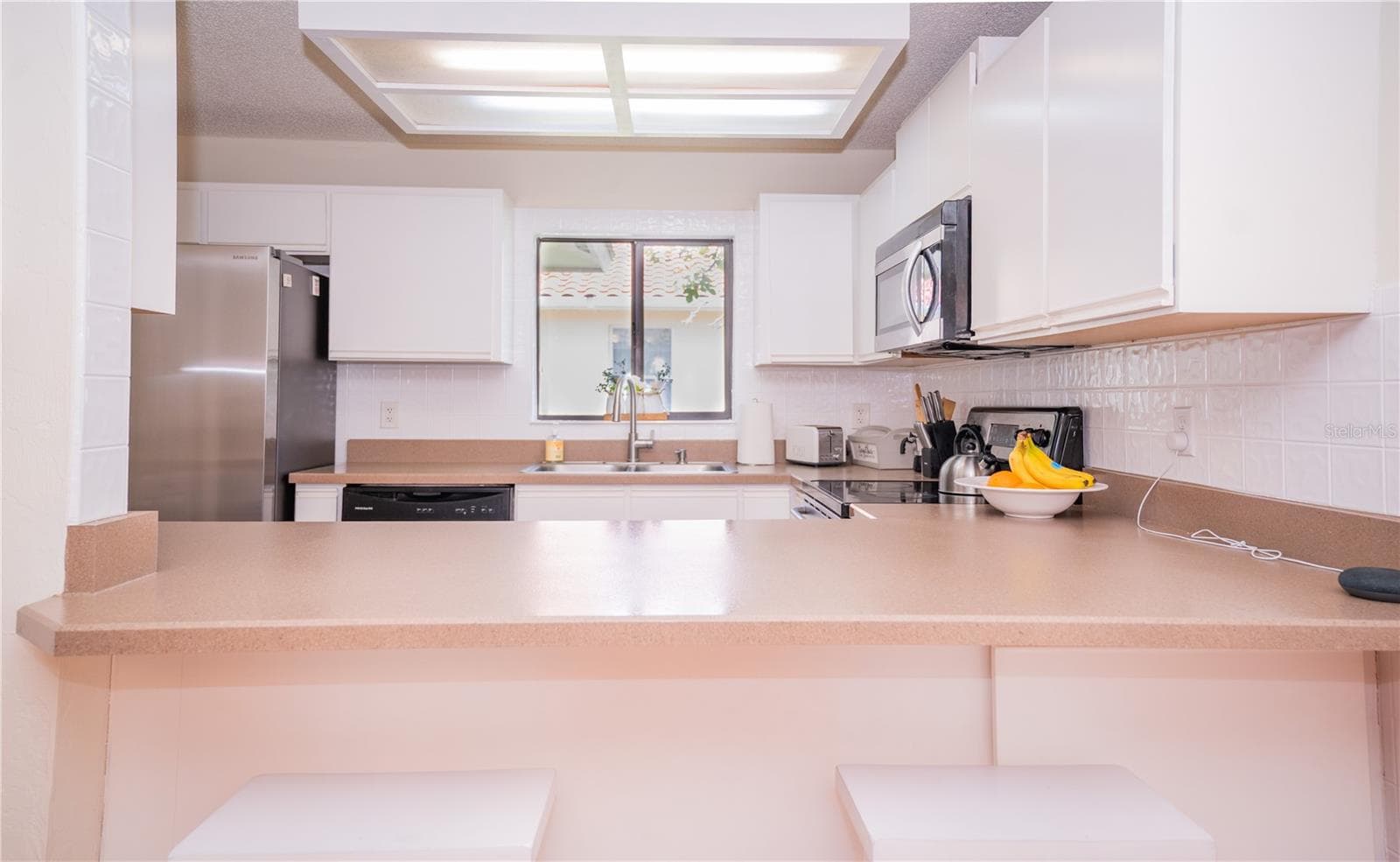 This bright and airy kitchen is the heart of the home, featuring abundant natural light and a convenient breakfast bar. - 57 FORRESTER PL, PALM COAST