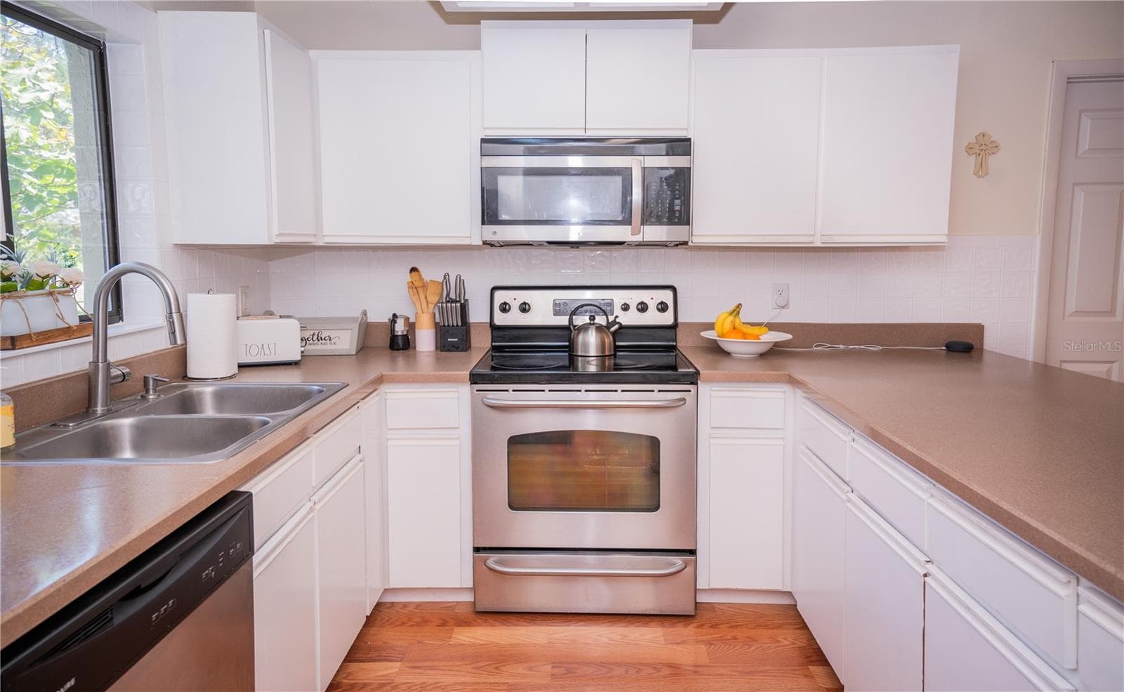 Modern kitchen featuring stainless steel appliances, including a range and built-in microwave. - 57 FORRESTER PL, PALM COAST